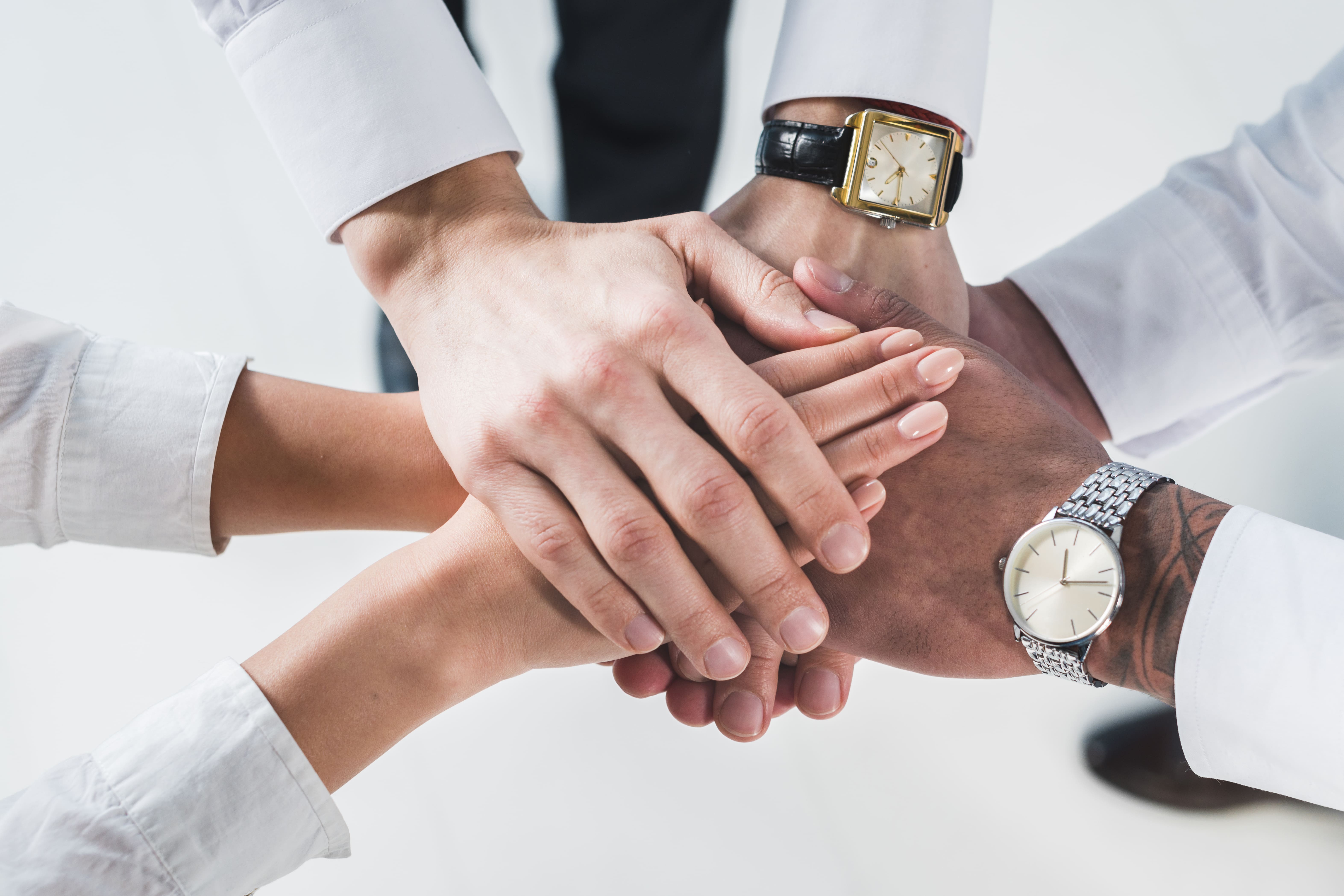 people-putting-stacked-hands-together-promising-help-support-against-white-backdrop (1)